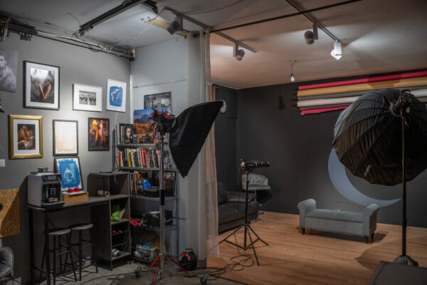 Panoramica dello studio fotografico a Trieste: parete nera con la luna, octabox, fondali colorati e pavimento in legno